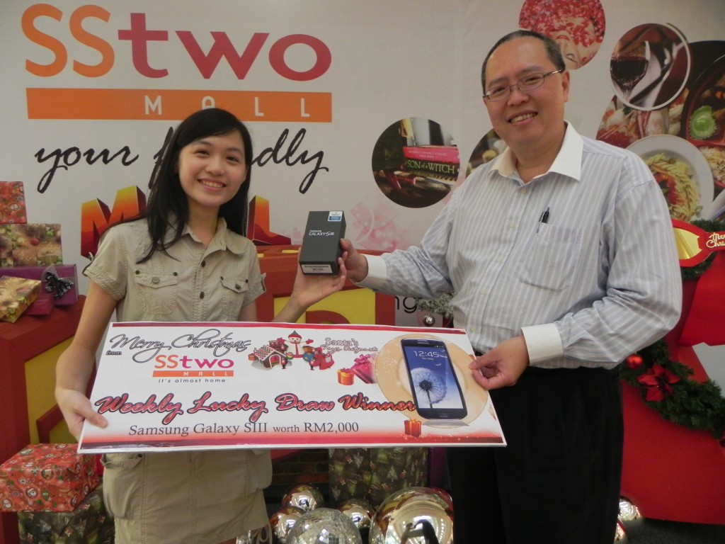 Director of Operations Mr Vincent Chong giving Yen Ni her Samsung Galaxy S III