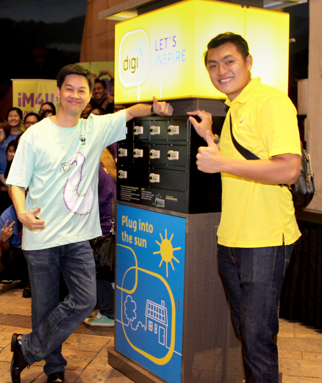Digi Sustainability Manager Philip Ling (left) with the solar-powered device charging station
