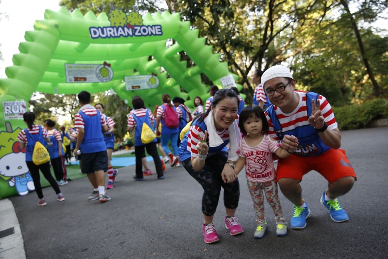 Mum and dad clad in the Hello Kitty race attire with their toddler stop by to pose at the Durian checkpoint