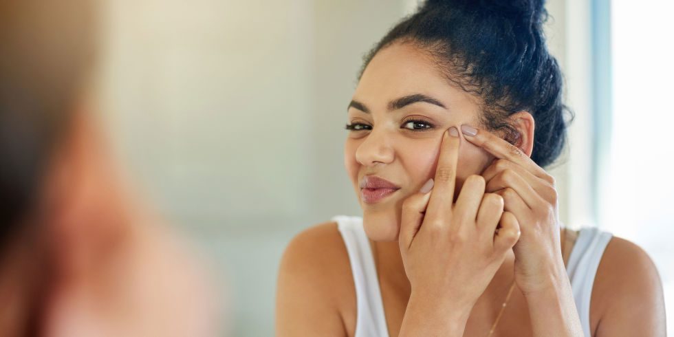 landscape 1487000700 woman looking in mirror squeezing spots